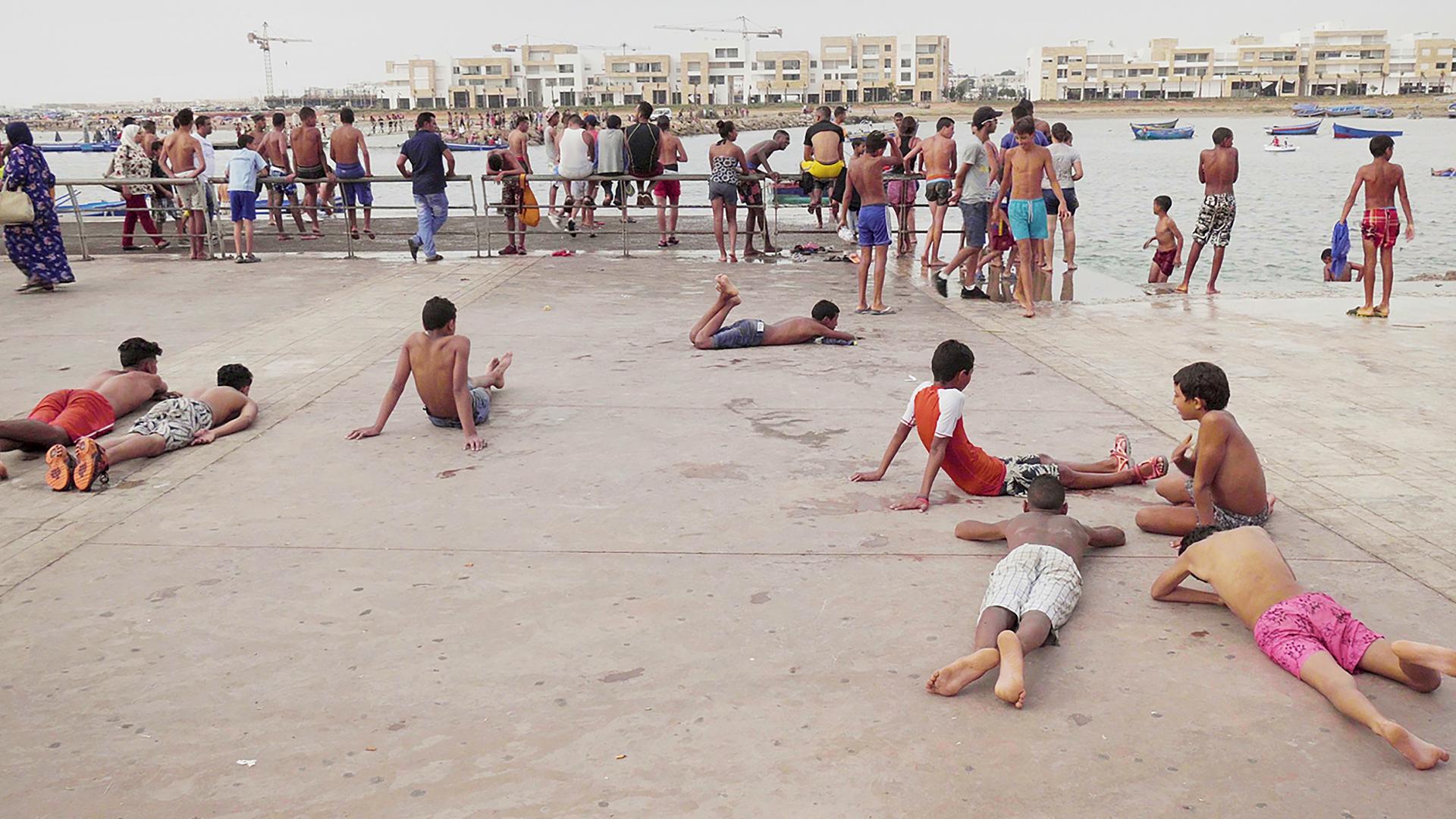 ragazzi in costume su una banchina affacciata sull'acqua